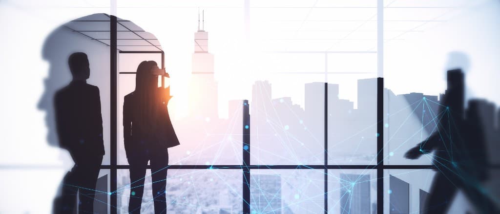 Silhouettes in a glass office looking out over a city, overlaid with a network of connections